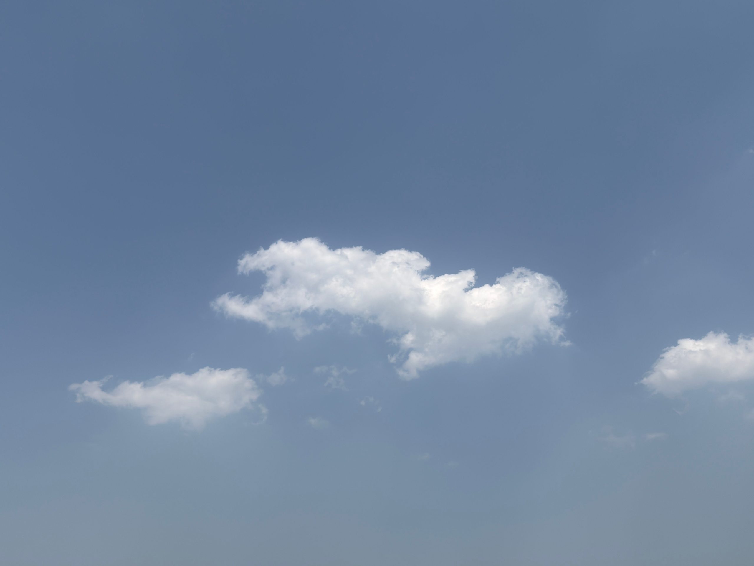 Gentle clouds float in a clear blue sky, conveying peace and tranquility.